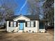 Charming white house with black shutters, light blue door, and a well-maintained yard at 407 E Talleyrand Ave, Monroe, NC 28112