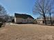 A charming home's back exterior showcases large windows overlooking the yard with a classic fence surrounding the property at 4407 Esherwood Ln, Charlotte, NC 28270