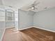 Bedroom with wood floors, ceiling fan, and a large arched window at 4407 Esherwood Ln, Charlotte, NC 28270