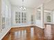 Bright dining room featuring hardwood floors, white shutters, and a modern chandelier at 4407 Esherwood Ln, Charlotte, NC 28270