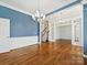 Elegant room featuring hardwood floors, blue accent wall, crown molding, and staircase view, highlighting the home's architectural features at 4407 Esherwood Ln, Charlotte, NC 28270