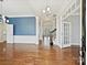 Elegant living room featuring hardwood floors, decorative molding, blue accent wall, and staircase access, showcasing the home's interior at 4407 Esherwood Ln, Charlotte, NC 28270