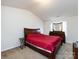 Main bedroom with a red bedspread and wooden furniture at 4529 Esmeralda Dr, Charlotte, NC 28269