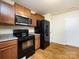 Modern kitchen with dark wood cabinets and black appliances at 4529 Esmeralda Dr, Charlotte, NC 28269