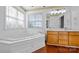 Bathroom features corner soaking tub and double vanity with wood cabinets at 507 Bearbrook Ln, Gastonia, NC 28052