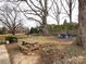 Large backyard with mature trees, a picnic table, and seating area at 509 Baucom Deese Rd, Monroe, NC 28110