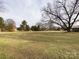 Flat backyard lawn surrounded by bare trees shows large home lot and neighborhood at 509 Baucom Deese Rd, Monroe, NC 28110