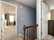 Second floor hallway with wooden railing and natural light from window in nearby bedroom at 509 Baucom Deese Rd, Monroe, NC 28110