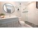 Modern bathroom with gray vanity, white tile shower, and round mirror at 532 Scaleybark Rd, Charlotte, NC 28209