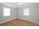 This bedroom has hardwood floors, light gray walls, white trim, and two windows that provide natural light at 532 Scaleybark Rd, Charlotte, NC 28209