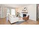 Bright living room featuring a brick fireplace, hardwood floors, and sliding glass doors to the backyard at 532 Scaleybark Rd, Charlotte, NC 28209