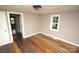 Bedroom with hardwood floors, a window, and access to another room at 700 Oak St, Charlotte, NC 28214