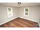 Simple bedroom with hardwood floors and two windows at 700 Oak St, Charlotte, NC 28214