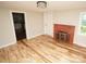 Living room with hardwood floors and brick fireplace at 700 Oak St, Charlotte, NC 28214