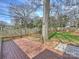 Large backyard with a deck, mature trees, a wooden fence, and a well-maintained lawn at 833 Montford Dr, Charlotte, NC 28209