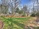 A grassy backyard with a privacy fence, landscaping, and mature trees at 833 Montford Dr, Charlotte, NC 28209