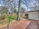 Spacious backyard featuring a wooden deck, lush green grass, mature tree, and wooden privacy fence at 833 Montford Dr, Charlotte, NC 28209