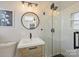 Modern bathroom with a glass shower, stylish vanity, round mirror and a soft, ambient lighting design at 833 Montford Dr, Charlotte, NC 28209