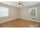 Minimalist bedroom offers hardwood floors, neutral walls, and natural light through two windows, creating a serene space at 833 Montford Dr, Charlotte, NC 28209