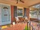 Inviting front porch featuring stylish chairs, table, and a 'hello' door mat with terra cotta tile at 833 Montford Dr, Charlotte, NC 28209