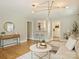 Bright living room showcasing hardwood floors, a modern chandelier, and an open layout with kitchen view at 833 Montford Dr, Charlotte, NC 28209