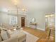 Cozy living room featuring hardwood floors, a stylish light fixture, and seamlessly connected dining space at 833 Montford Dr, Charlotte, NC 28209