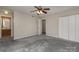 Bright bedroom with grey carpet, ceiling fan, and en-suite bathroom at 9153 Spyglass Pl # B, Charlotte, NC 28214