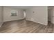 Living room with wood-look flooring, neutral walls, and an entryway view at 9153 Spyglass Pl # B, Charlotte, NC 28214