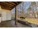 Brick patio with wooden bench and wooded backdrop at 9153 Spyglass Pl # B, Charlotte, NC 28214