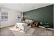 Cozy bedroom with a green accent wall, hardwood floors, and ample natural light at 9706 Hamel St, Charlotte, NC 28215