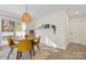 Modern dining area with a wooden table and yellow chairs, adjacent to the kitchen at 9706 Hamel St, Charlotte, NC 28215