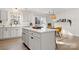 Bright kitchen with an island, white cabinets and a view to the dining area at 9706 Hamel St, Charlotte, NC 28215