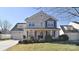 Two-story house with beige siding, two-car garage, and landscaping at 9806 Penn Station St, Cornelius, NC 28031