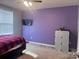 This bedroom offers a ceiling fan, window, television, and wall-mounted shelves at 1148 Tangle Ridge Se Dr, Concord, NC 28025