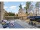 Spacious back deck with a grill, outdoor seating, and views of the backyard and trees at 14018 Promenade Dr, Huntersville, NC 28078