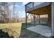Large backyard features a covered patio, grass, brick wall, and metal fencing at 14018 Promenade Dr, Huntersville, NC 28078