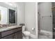 Well-lit bathroom features a granite countertop, dark cabinetry, and a shower with gray tile at 14018 Promenade Dr, Huntersville, NC 28078