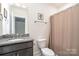 Bright bathroom featuring a granite countertop, vanity with a toilet and shower with a neutral-tone curtain at 14018 Promenade Dr, Huntersville, NC 28078