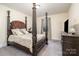 Inviting bedroom featuring an elegant four-poster bed, soft lighting, and carpet at 14018 Promenade Dr, Huntersville, NC 28078