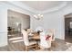 Open concept dining room with a wood table, elegant chairs, and a decorative chandelier at 14018 Promenade Dr, Huntersville, NC 28078