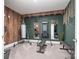 Modern home gym with motivational decor, including weights, mirrors, and wood accent wall at 14018 Promenade Dr, Huntersville, NC 28078