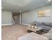 Spacious living room features a gray couch, carpet flooring, recessed lighting, and light green walls at 14018 Promenade Dr, Huntersville, NC 28078