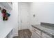 Mudroom with built-in shelving, coat hooks, granite countertops, and light wood floor at 14018 Promenade Dr, Huntersville, NC 28078