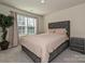 Bedroom with a gray upholstered bed frame, soft carpet, and a large window letting in natural light at 14041 Castle Nook Dr # 75, Charlotte, NC 28273