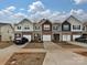 Charming townhome exteriors featuring brick accents and attached garages, set against a blue sky with lovely cloudscape at 14041 Castle Nook Dr # 75, Charlotte, NC 28273
