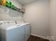 Clean laundry room with a modern washer and dryer set on wood-look flooring with wire shelving at 14041 Castle Nook Dr # 75, Charlotte, NC 28273