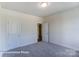 Clean bedroom with white walls, neutral carpet, and a door leading to a closet at 148 Prestwick Way # 21, Mooresville, NC 28115
