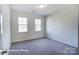 A bright bedroom with neutral carpet, white walls, and two large windows letting in natural light at 148 Prestwick Way # 21, Mooresville, NC 28115