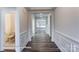 Hallway with dark wood floors, white wainscoting, and views of a nearby half bathroom at 148 Prestwick Way # 21, Mooresville, NC 28115