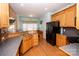 Kitchen boasts oak cabinets, black appliances, and an island at 219 Society Rd, Statesville, NC 28625